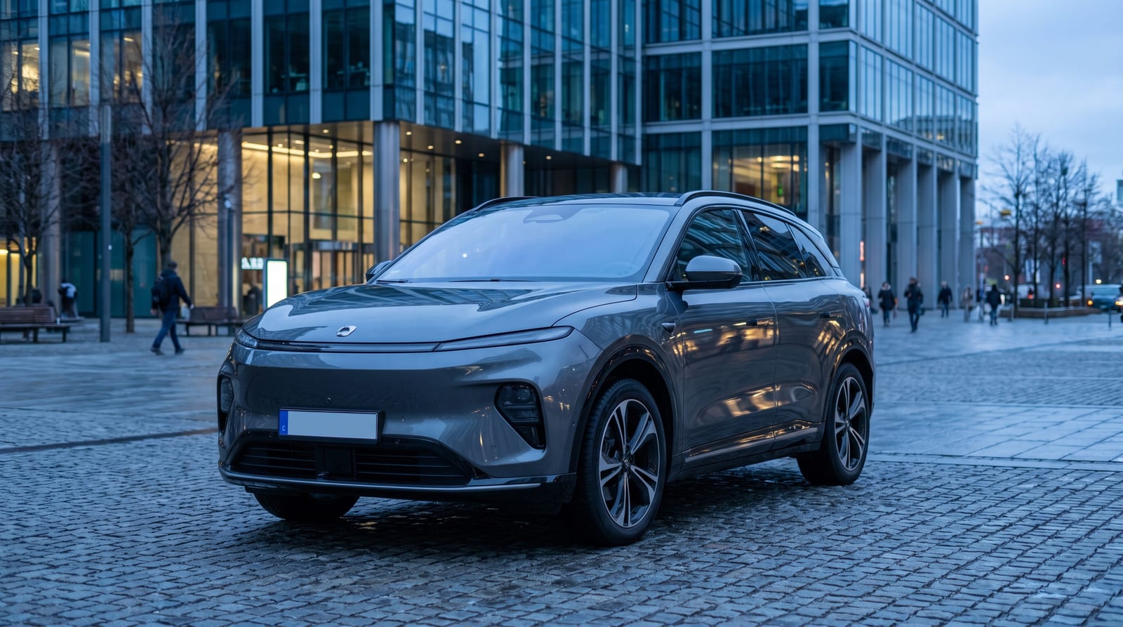 Mașină electrică chinezească parcată în fața unei clădiri administrative, lumină rece de seară, fără siglă vizibilă